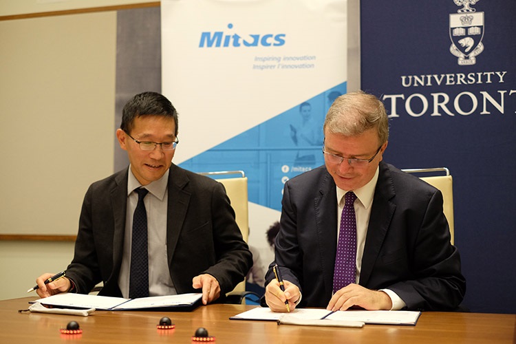 Christopher Yip, U of T’s associate vice-president of international partnerships, signs the funding agreement with Ridha Ben Mrad, Mitacs' chief research officer and associate academic director. Photo by Geoffrey Vendeville.
