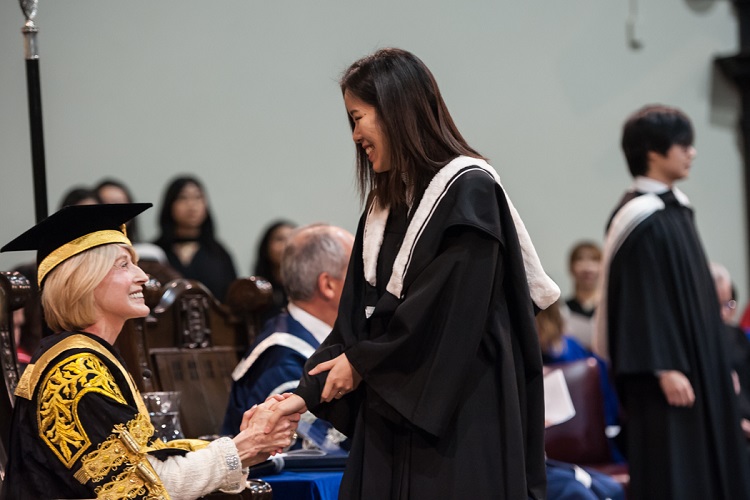 Chancellor Rose Patten shakes hands with a graduate in U of T's Convocation Hall in November, 2018. Photo by Lisa Sakulensky.