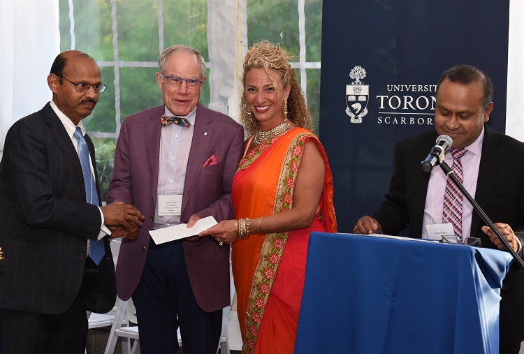Dr. Vijay Janakiraman (left) is greeted by Professor Bruce Kidd and Georgette Zinaty, executive director of development and alumni relations at U of T Scarborough. Sivan Ilangko is at the podium. Photo by Ken Jones.