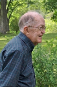 Ian Dalton smiles happily while standing in a garden.