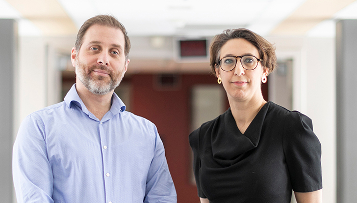 Robert Kozak and Samira Mubareka stand side by side in a hallway.