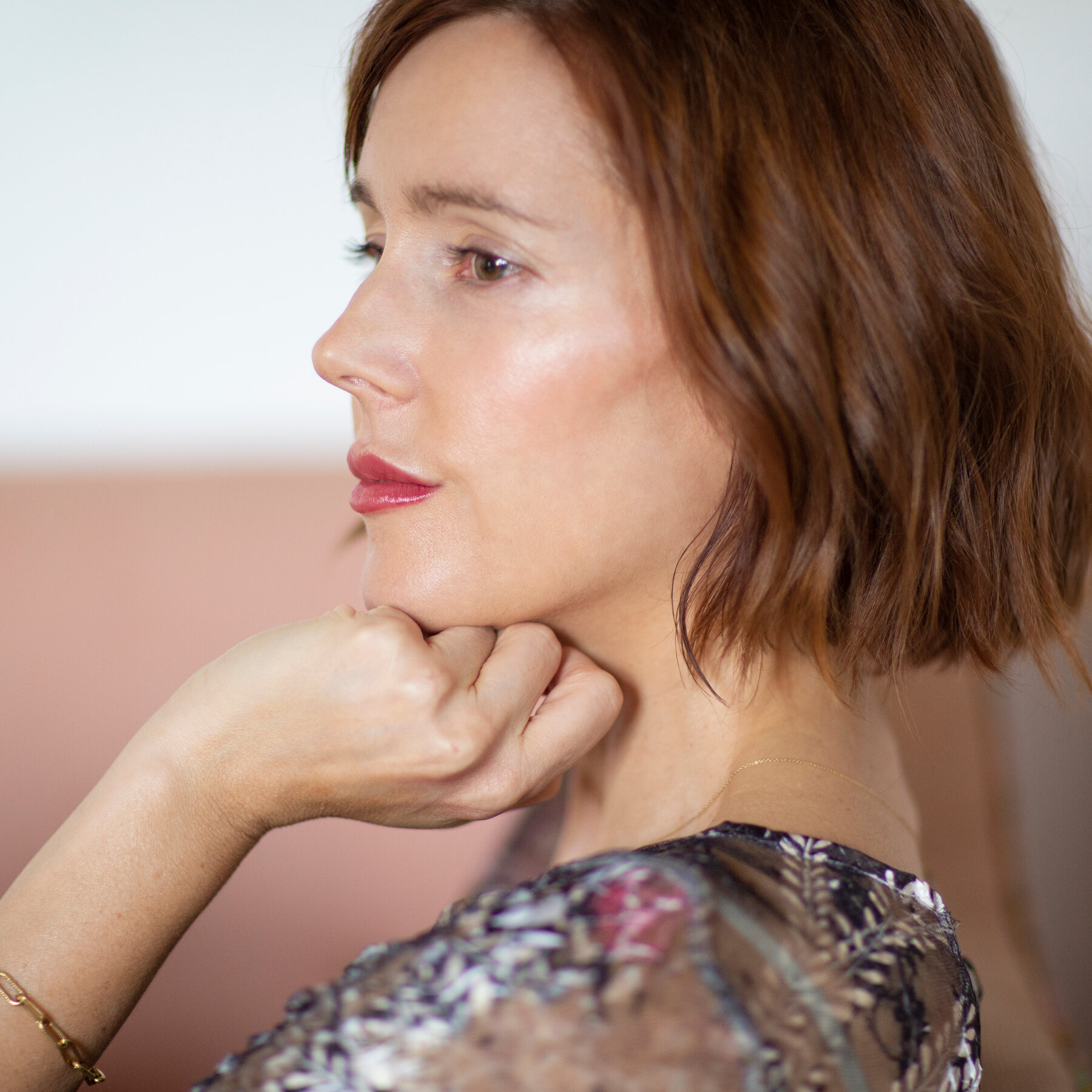 Headshot of Michelle Orange looking into the distance with chin resting on hand.