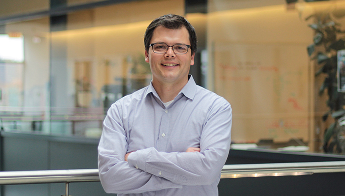 Keith Pardee smiles while standing in an atrium indoors.