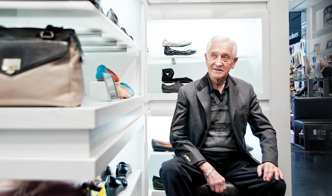 Leonard Simpson, seated in front of shelf with shoes.