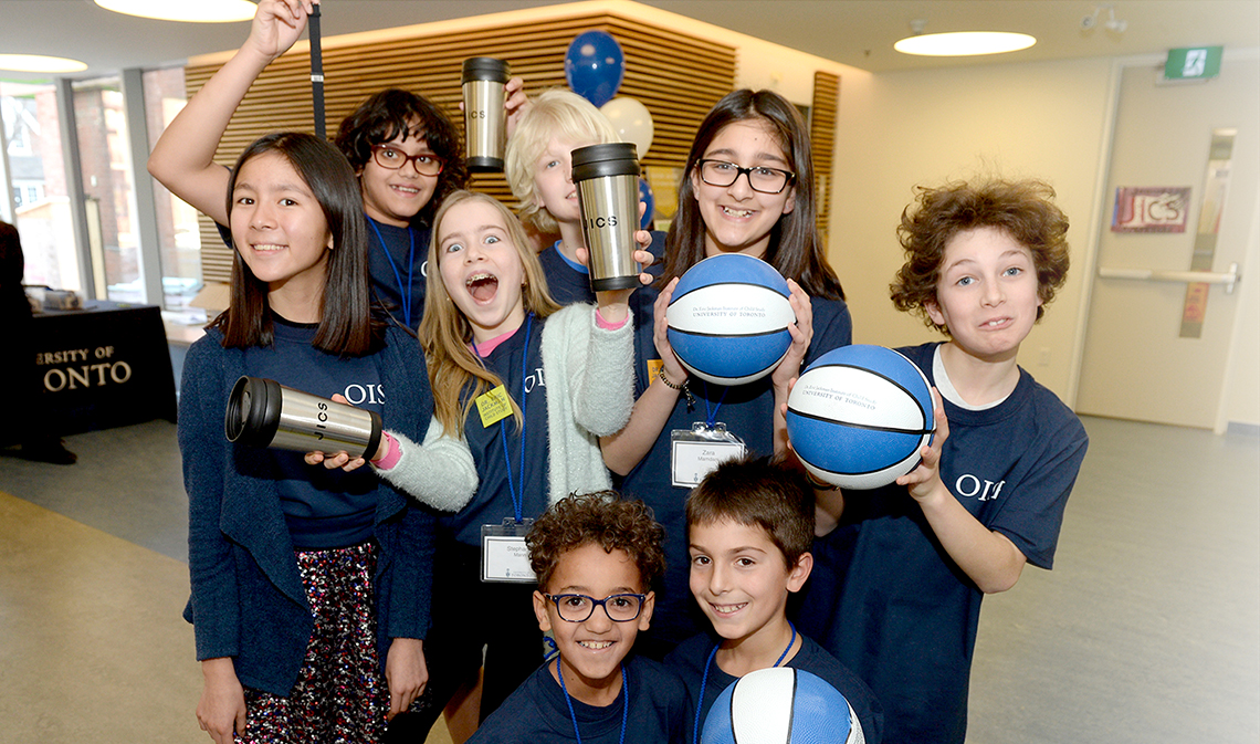 Elementary school students smiling and holding basketballs inside at the official opening of the Dr. Eric Jackman Institute of Child Study