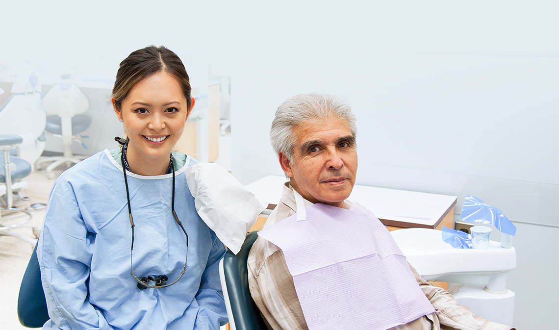 Dentistry student Carolyn Chuong, seated next to patient Oscar Rios.