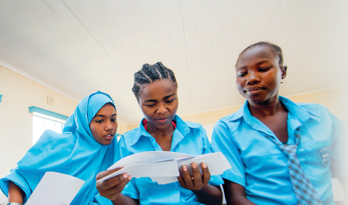 Three students looking at a piece of paper.