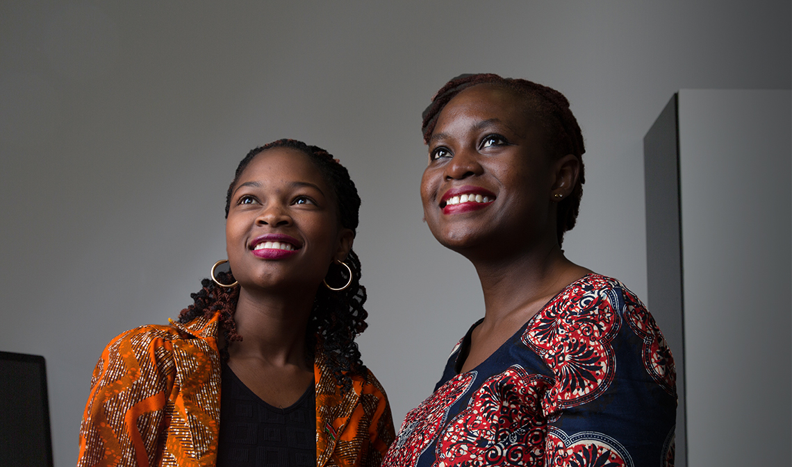 Emmanuela Alimlim (left) smiles with woman, looks on in distance.